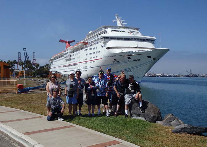 group in front of a cruise ship