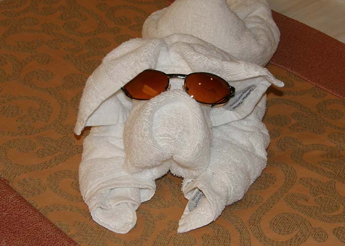 a white towel shaped like a pig wearing sunglasses funny